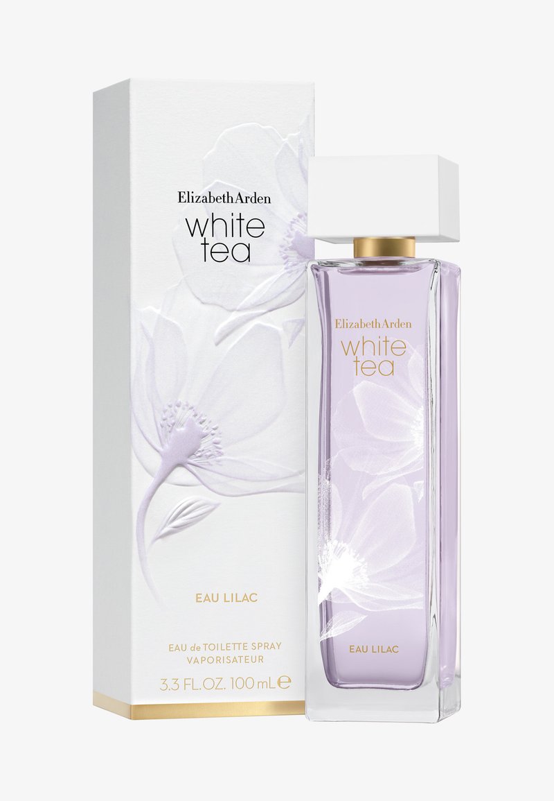 Bouteille en verre transparent avec une teinte lavande, capuchon blanc carré. L'emballage présente un design floral blanc, des accents dorés et du texte sur le produit.