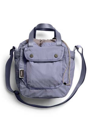 Sac à bandoulière en tissu violet clair avec une poche à rabat à l'avant, des poignées supérieures, une bandoulière ajustable et une fermeture à cordon sur fond blanc.