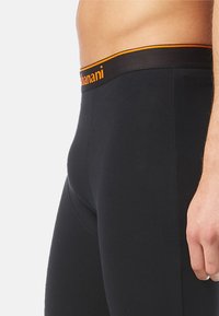 Black fitted leggings with a soft texture and an elastic waistband featuring an orange brand logo on the front.