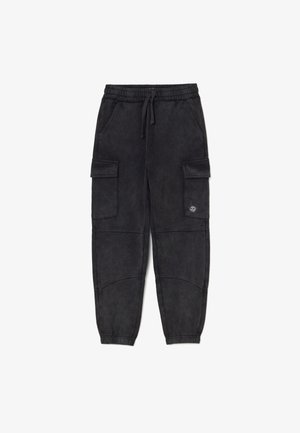 Schwarze Cargo-Jogginghose mit elastischem Bund, Zugband, seitlichen Klappentaschen, gesteppten Knieflicken und Totenkopf-Flammenlogo auf der linken Tasche.