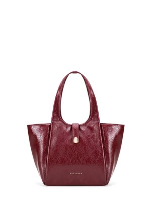 Bordeauxrode leren handtas met twee hengsels, een voorste knoopriem en kleine gouden logotekst onderaan in het midden.