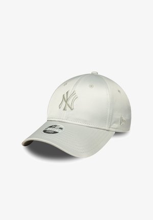Biała czapka z daszkiem New York Yankees z zaokrąglonym daszkiem i regulowanym paskiem, ozdobiona haftowanymi logo z przodu i po boku.