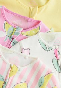 Tre tutine per neonati: gialla, rosa con stampa di limoni e bianca con design di tulipani. Materiale in cotone morbido, colletti arrotondati e zip frontali.