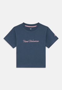 T-shirt cropped azul com o texto em rosa "New Balance" centralizado no peito e um pequeno logótipo em rosa na manga esquerda.