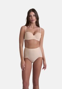 Beige formar underwire-bh i kombination med högmidjade trosor. Slät textur, justerbara band, minimalistisk design och sömlös finish.