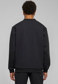 Zwarte sweatshirt met een ronde hals, lange mouwen, ribgebreide manchetten en zoom. Gemaakt van zachte stof, met een minimalistisch ontwerp zonder zichtbare logo's.