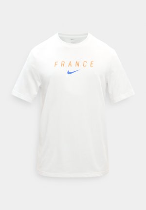 Bijela majica kratkih rukava s natpisom "FRANCE" narančastim slovima i plavim Nike logoom u obliku kvačice u sredini prsa.