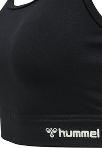 Zwarte sportbh van gladde stof, met een ronde halslijn en een in het wit bedrukt logo op de band. Naadloos ontwerp verhoogt het comfort.