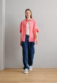 Roosa nööbiga särk, valge tank top, sinised teksad ja heledatest hallidest tennistest. Sile kangas, mugav lõige, üleskeeratud varrukad. Lihtne disain.