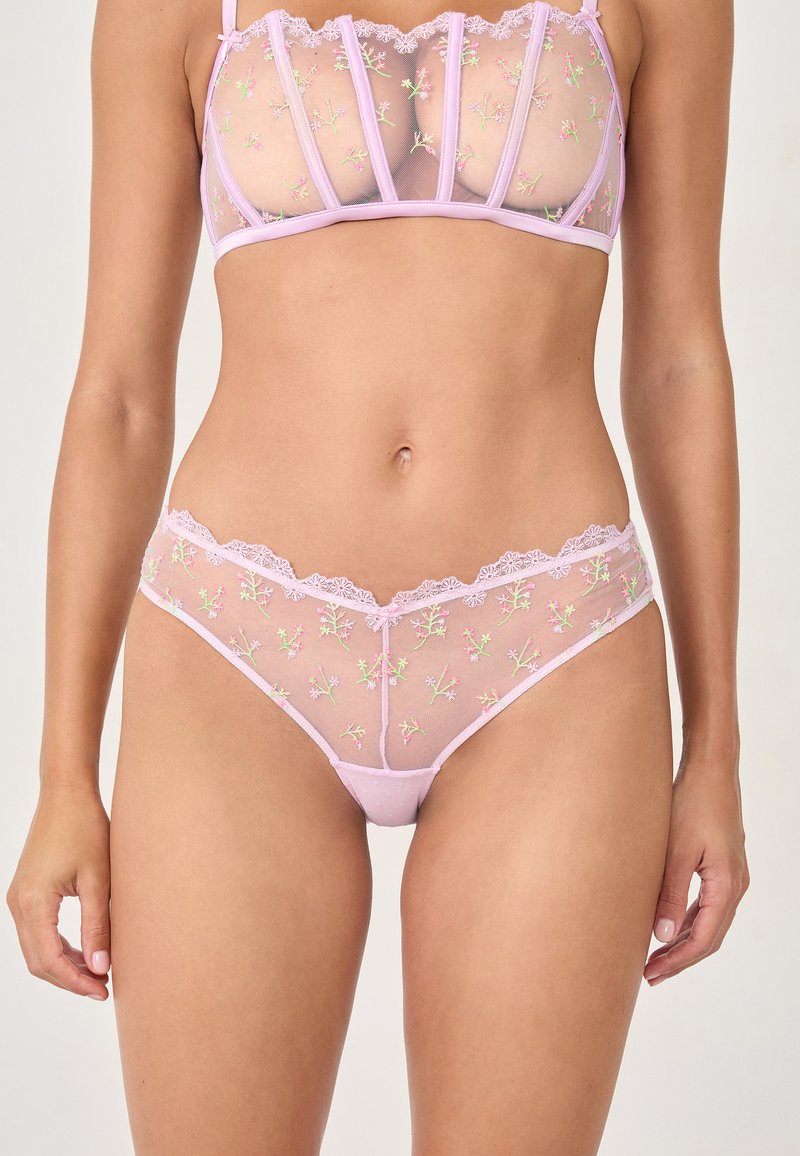 Durchsichtiges rosa Dessous-Set mit floralen Stickereien, Spitzenverzierungen und geformten Cups. Netzstoff sorgt für Textur und Detail.