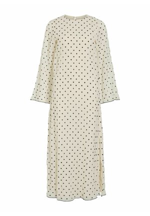 Lang kremhvit kjole med svarte polkadotter, rund halslinning og lange, lett vidde ermer. Har en sidesplit og subtil detaljering ved kanten.