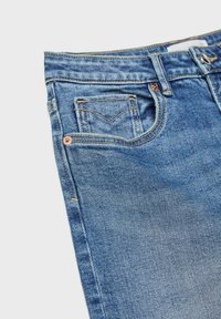 Svijetloplave trapke od denima s klasičnim dizajnom s pet džepova, kontrastnim šavovima i blagim izblješnjenjem na teksturi tkanine.