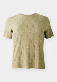Short-sleeve top in light olive green with a textured surface featuring a diamond pattern and circular cut-outs throughout the fabric.