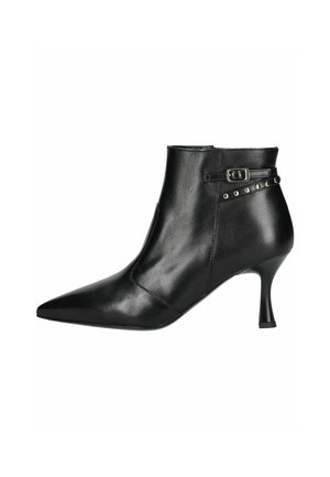 Bottine en cuir noir avec un bout pointu, un talon fin et une accentuation par boucle. Présente des clous décoratifs sur le côté pour un ajout de détail.