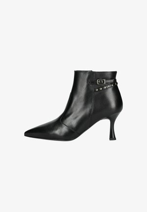 Bottine en cuir noir avec un bout pointu, un talon fin et une accentuation par boucle. Présente des clous décoratifs sur le côté pour un ajout de détail.