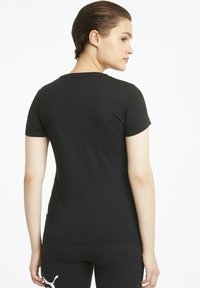 Camiseta de manga corta negra, hecha de tejido suave, con cuello redondo y una textura lisa, de corte ajustado. Sin logos visibles.