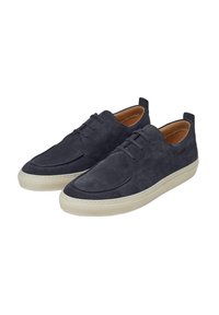 Zapatillas de ante azul marino con acabado liso, puntera redonda, cordones mínimos y suela de goma beige contrastante. Cuenta con una lengüeta en el talón.