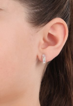 Pendiente de aro de plata que cuenta con tres filas de pequeñas piedras preciosas de colores. El diseño es elegante con un acabado pulido, ajustándose cómodamente al lóbulo de la oreja.