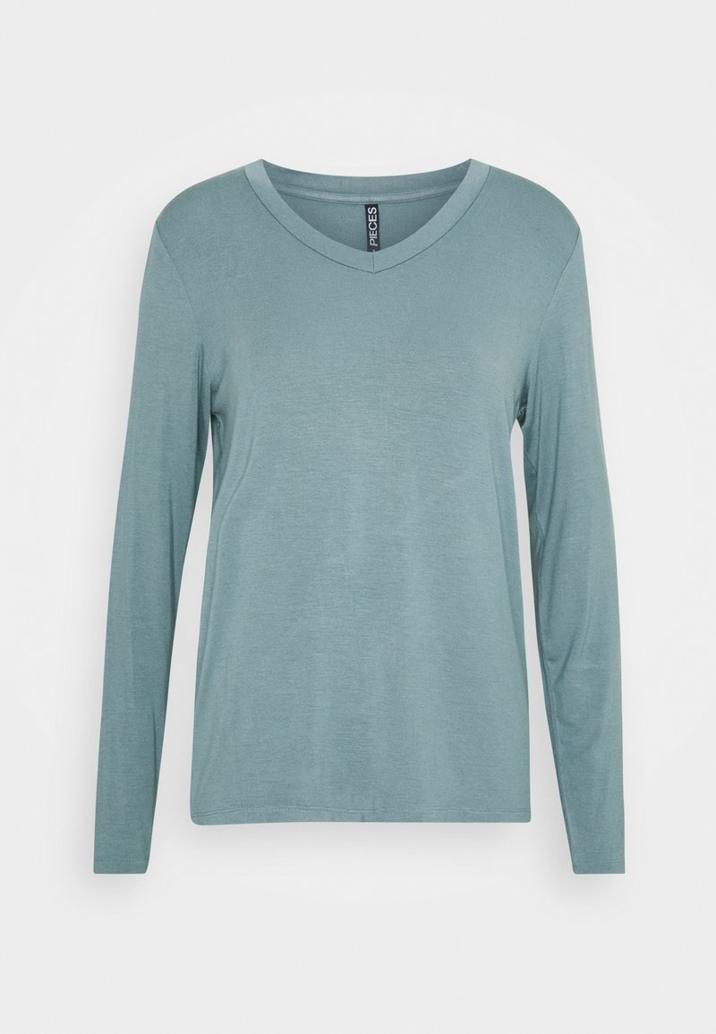 Långärmad topp med v-ringning i en mjuk, dämpad teal färg, visad mot en vit bakgrund.