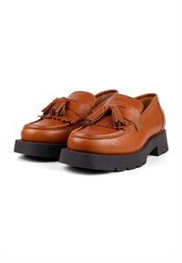 Braune Lederslipper mit strukturiertem Finish, verziert mit Quasten und einer dicken schwarzen Gummisohle, die ein klobiges Design bietet.