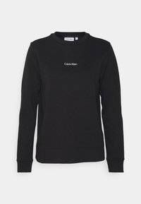 Felpa nera a maniche lunghe con scollo tondo, logo "Calvin Klein" al centro del petto, realizzata in tessuto morbido, taglia piccola.