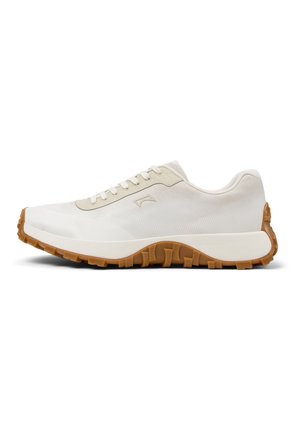 Sneaker bianco a taglio basso con accenti beige, suola intermedia spessa bianca e suola esterna in gomma marrone robusta progettata per aderenza e comfort all'aperto.