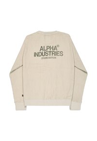 Beżowa bluza z długim rękawem o splocie waflowym z napisem „ALPHA INDUSTRIES STUDIO EDITION” nadrukowanym na plecach ciemnozielonymi literami.