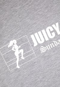 Pilkos medvilnės marškinėliai su baltu siluetu, vaizduojančiu žmogų, sportuojantį, ir tekstu "JUICY" bei "Sundaze" skirtingais šriftais.