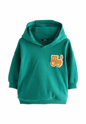 Haut à capuche vert pour enfants avec une petite patch en relief de train jaune sur le côté gauche de la poitrine et des poignets et un ourlet côtelés.