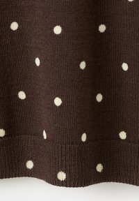 Tissu tricoté marron avec de petits pois blancs espacés régulièrement et un ourlet côtelé au bord inférieur.