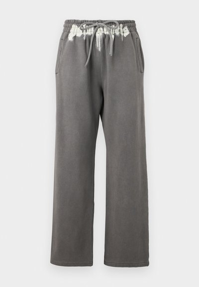 Γκρι φόρμα με κορδόνι στη μέση, πλαϊνές τσέπες και ξεθωριασμένο λευκό μοτίβο tie-dye στην κορυφή. Κατασκευασμένη από απαλό, υφασμένο ύφασμα.