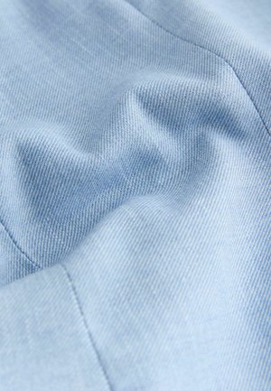 Gaiši zilas pinuma audums ar smalku tekstūru un smalku spīdumu, ar slīpu ribu rakstu un gludu, mīkstu virsmu. Redzama šuve.