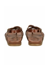 Hnědé sandály s plochou podrážkou a nastavitelným páskem na kotníku, vyrobené z měkké semišové materiálu a s polstrovanou stélkou pro pohodlí.