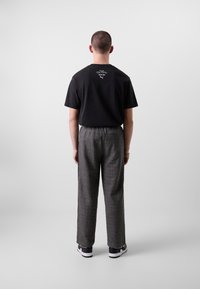 Puma RELAXED TRACK PANTS - Trainingsbroek - black/alpine snow