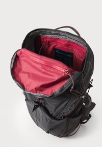 Zaino in tessuto grigio con interno rosso, dotato di una cerniera superiore e una tasca interna. Regolazioni notevoli con dettagli e accessori rossi.