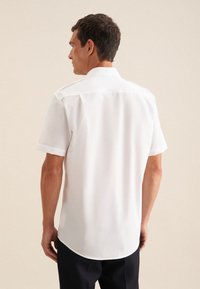 Korte mouwen, overhemd met kraag in witte stof met een gladde textuur. Heeft een gebogen zoom en een schoon, minimalistisch ontwerp.