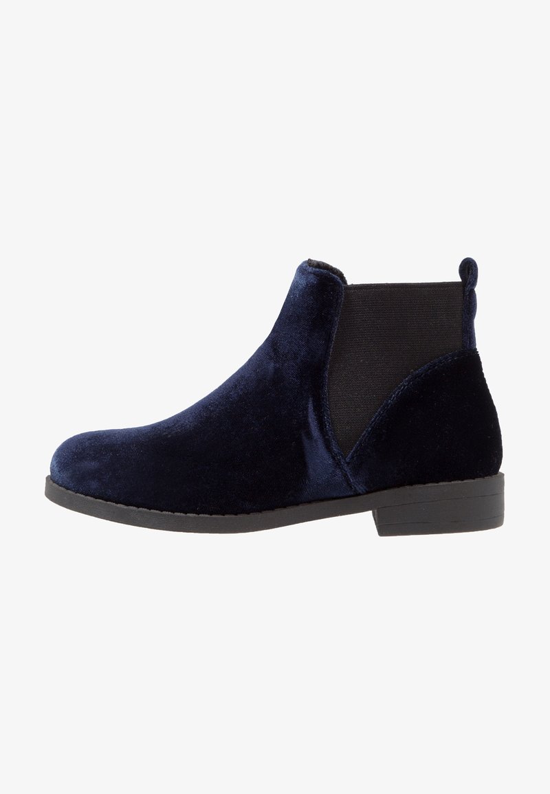 Bottine Chelsea en velours bleu marine avec empiècements latéraux élastiques noirs et semelle à talon bas noire.
