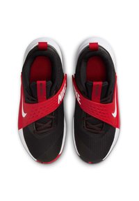 Baskets de sport noires et rouges avec une tige en maille, large sangle rouge, logo Nike blanc et semelle en caoutchouc. Elles présentent un intérieur rembourré et des accents texturés.