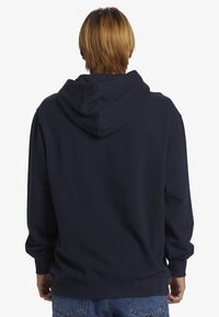 Felpa blu navy con cappuccio regolabile, maniche lunghe e polsini a coste. Tessuto in cotone liscio con vestibilità comoda e senza loghi visibili.