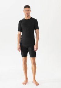 Zwart sportshirt met korte mouwen en donkere korte broek, met een aansluitend ontwerp en een gladde textuur, geschikt voor actieve wear.
