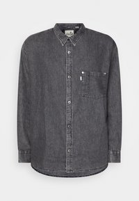 Camicia in denim grigia con colletto button-down, tasca frontale, chiusura a bottoni e orlo curvo con cuciture a vista.