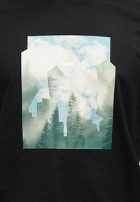 Μαύρο μπλουζάκι με γραφικό σχέδιο αφηρημένων κτιρίων και δέντρων, με φόντο από ανοιχτό μπλε και λευκά σύννεφα και το κείμενο «BOSS».