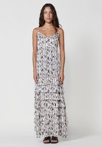 Robe maxi avec un design en couches, fabriquée en tissu léger avec un motif abstrait rose et noir et des bretelles fines.