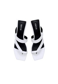 Witte hoge sandalen met een vierkante neus, met twee overlappende banden, een gestructureerde bovenkant en een contrasterende zwarte binnenzool, gelabeld "EDITED."