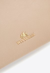 Portafoglio in pelle texturizzata beige con logo dorato "WITTCHEN" e stemma decorativo. Il design è liscio con una leggera lucentezza.