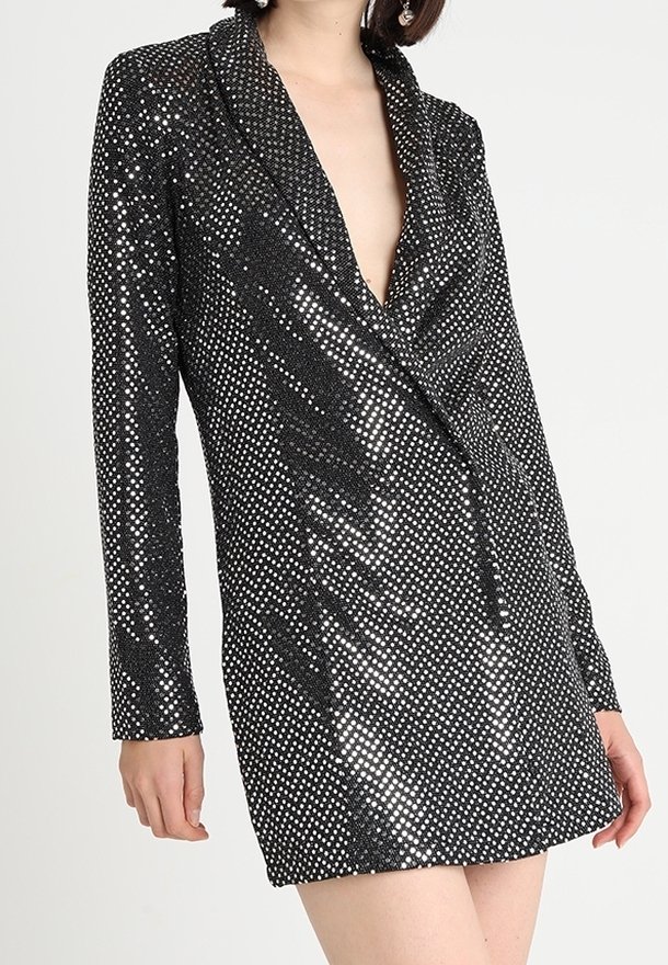 Black sequined blazer dress with a deep V-neck, long sleeves, and a tailored silhouette, featuring a glimmering dot pattern throughout.