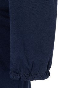 Navyblauwe katoenen mouw met een geraffineerde manchet, voorzien van een gladde textuur en een effen kleur, ontworpen voor een getailleerde pasvorm.