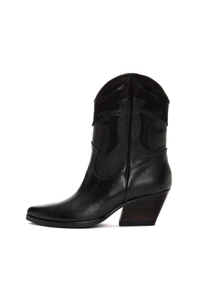 Bota de cuero negro de cowboy con punta afilada, costuras decorativas y tacón de madera en ángulo.