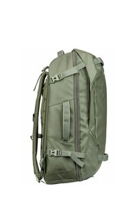 Sac à dos en nylon vert avec des bretelles rembourrées, plusieurs compartiments de rangement et des boucles réglables. Poche en maille sur le côté visible.