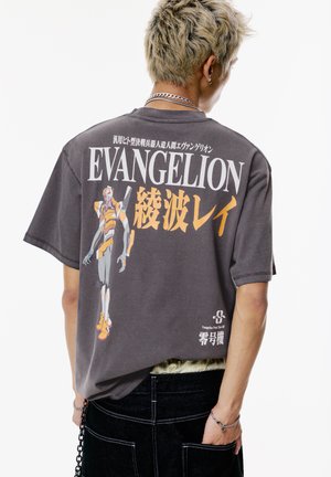 Gray oversized t-shirt featuring a graphic print of a character in orange and yellow tones, with Japanese text above and below.
